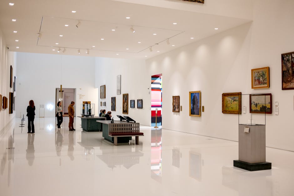 Spacious modern art museum with visitors browsing paintings and exhibits.
