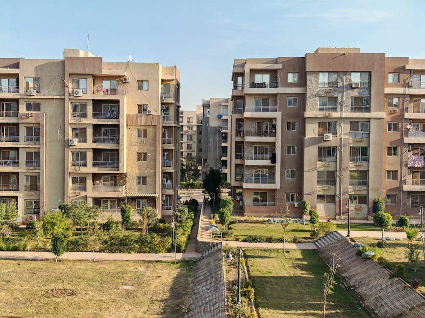Aerial view of modern apartment buildings with a landscaped courtyard, showcasing urban living.